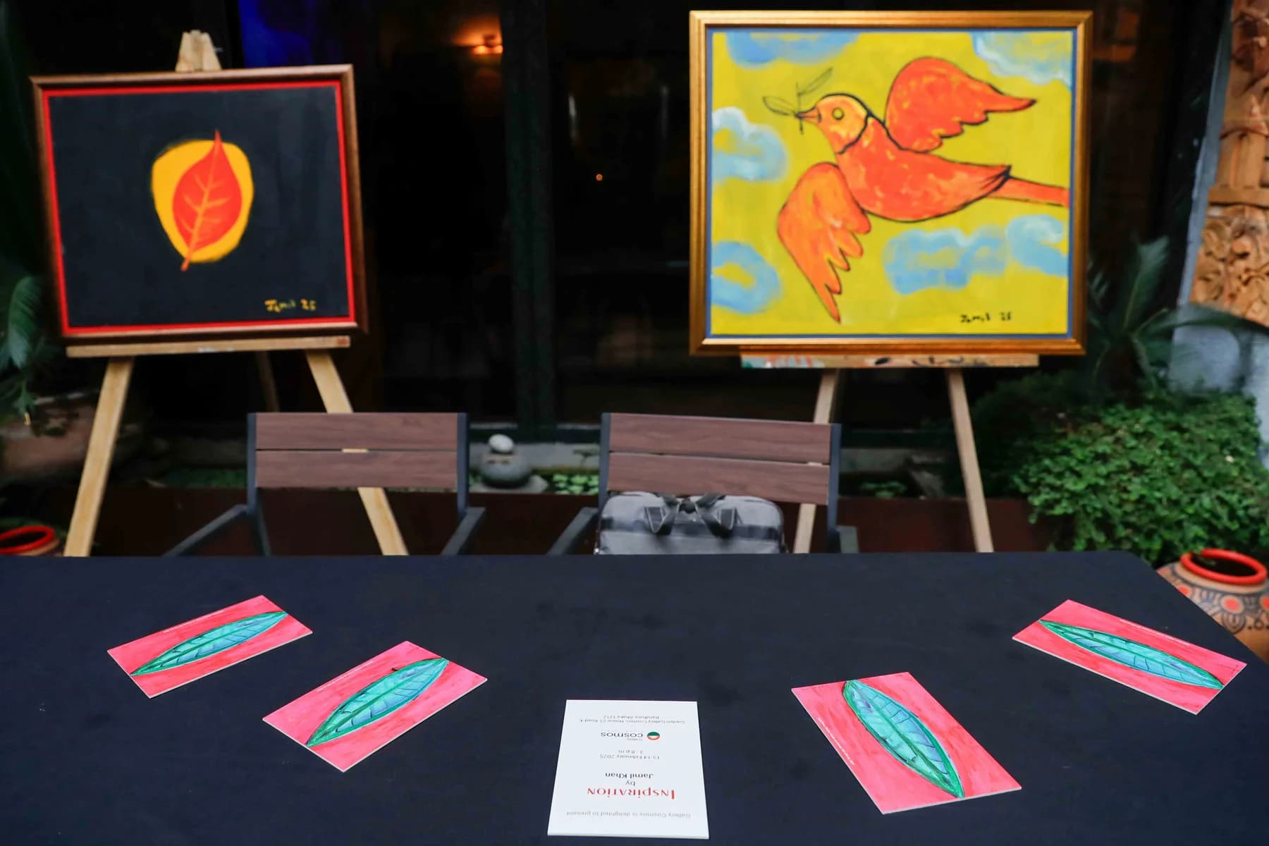 Paintings on easels beside the display table — Imagination, a presentation of work by Jamil Khan at Gallery Cosmos