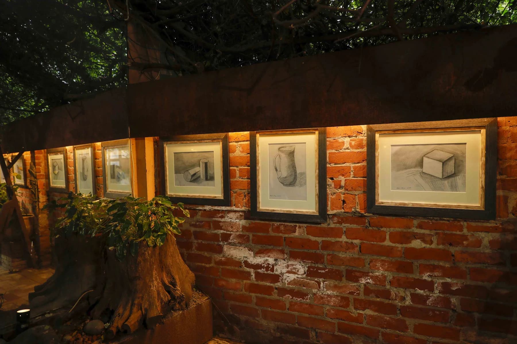 Drawings lit along the garden wall — Inspiration, a solo exhibition by Jamil Khan at Gallery Cosmos