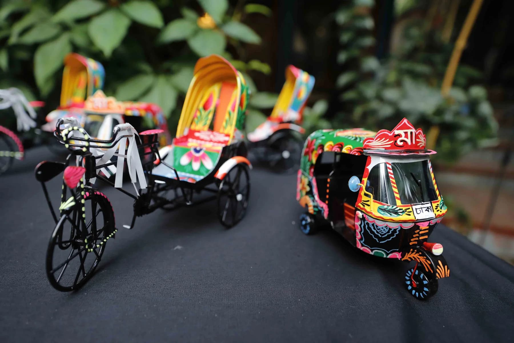 Miniature rickshaws on the display table — Rickshaw Art Exhibition at Gallery Cosmos